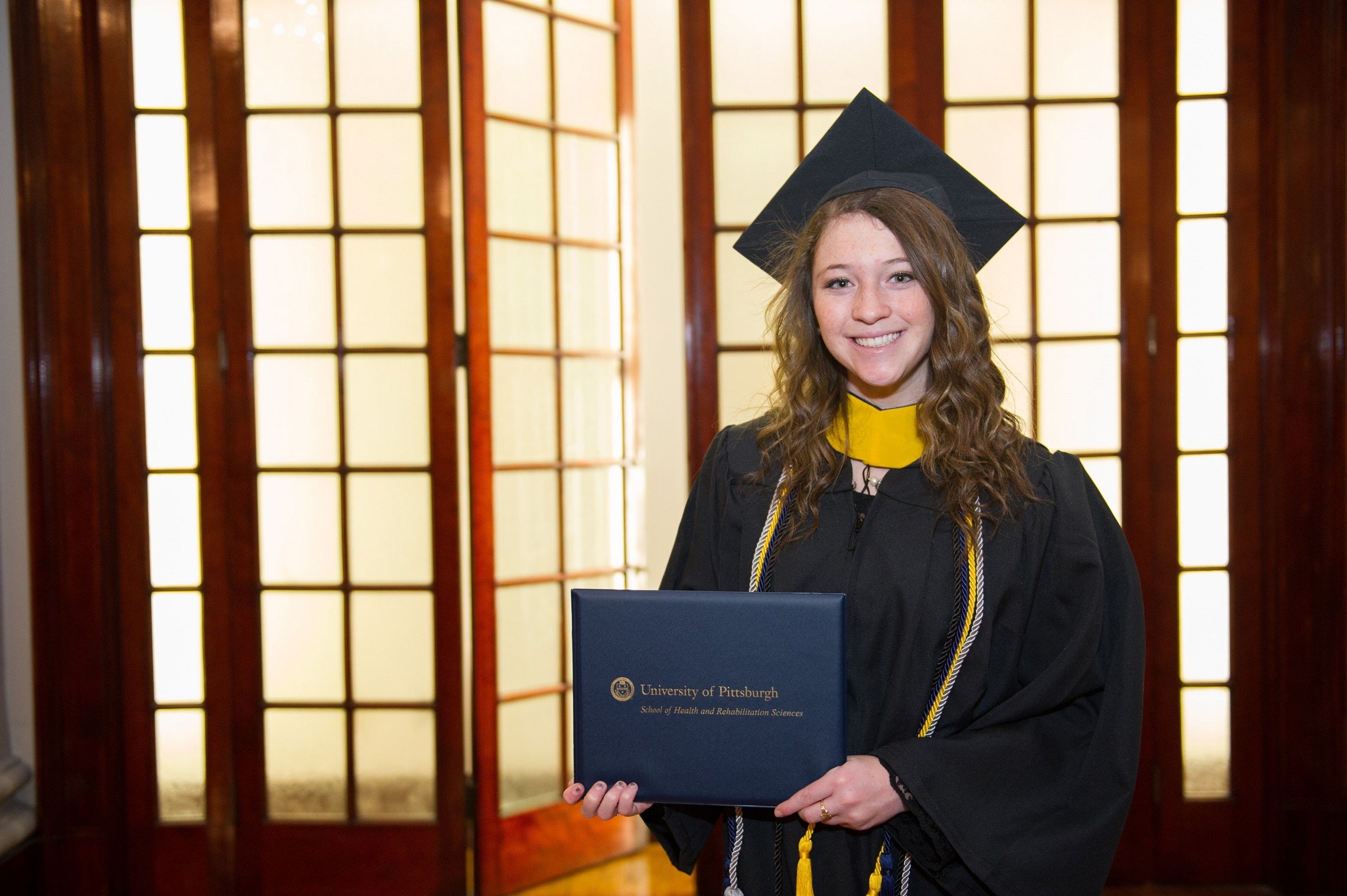 Student in regalia holding degree