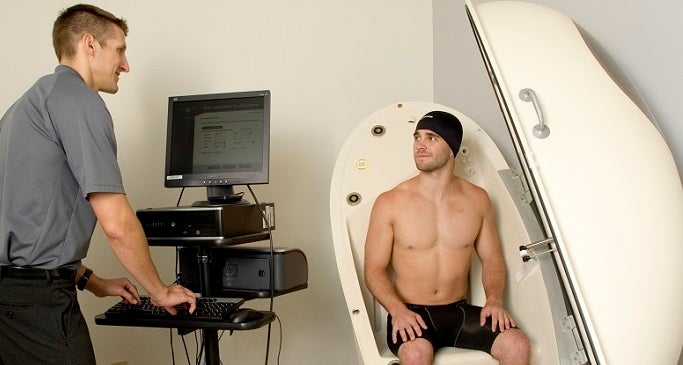 Researcher with student in lab using Bod Pod