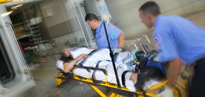 Paramedics rushing patient into ambulance