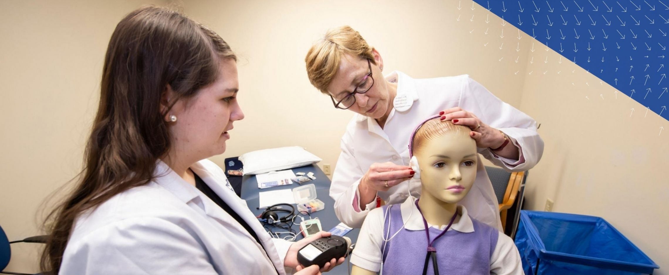 instructor and student with audiology mannequin