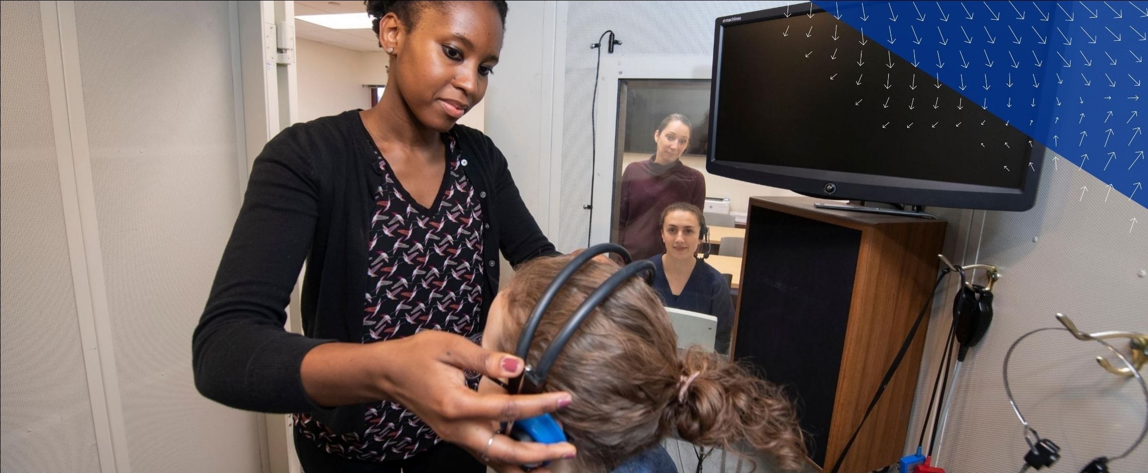 researchers putting headphones on participant