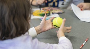 Child holding tennis ball