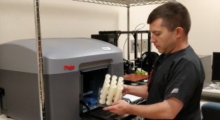 Alumnus working with 3D printer