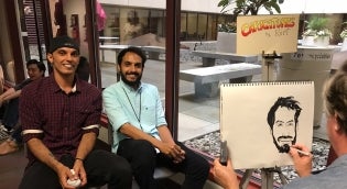 Students posing for caricature artist
