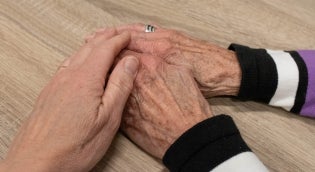 Caregiver holding older adult hands