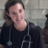 A doctor with a stethoscope around her neck smiling