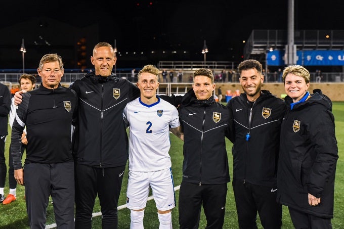Proessl (third from right) with Pitt Men’s Soccer head coach Jay Vidovich (left), players, coaches and staff