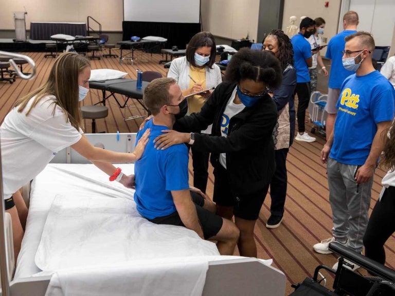 Students and instructors at the David Lawrence Convention Center participating in physical therapy workshops and instructional sessions.
