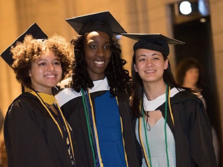 Three students in regalia on graduation day