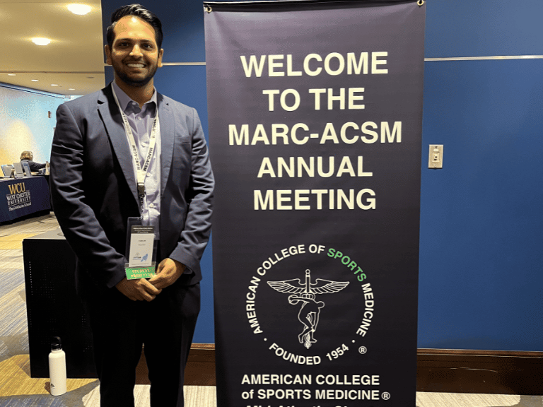 Varun Patel in front of the American College of Sports Medicine Mid-Atlantic Chapter sign, where he presented his research.  