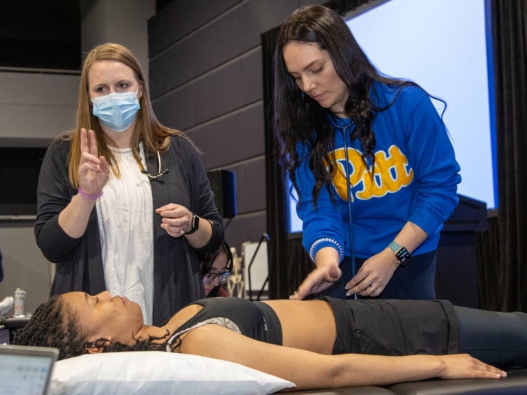 DPT Hybrid faculty member Kaylin Bullard (left) leads a group of students through fine-tuning their cardiovascular assessment techniques at the weeklong in-person immersion.