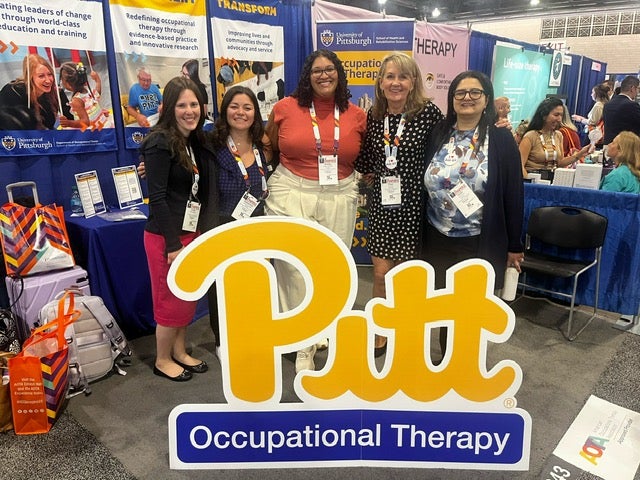 Five faculty and staff from Pitt OT standing behind a large cutout of the Pitt Script logo at a conference booth.