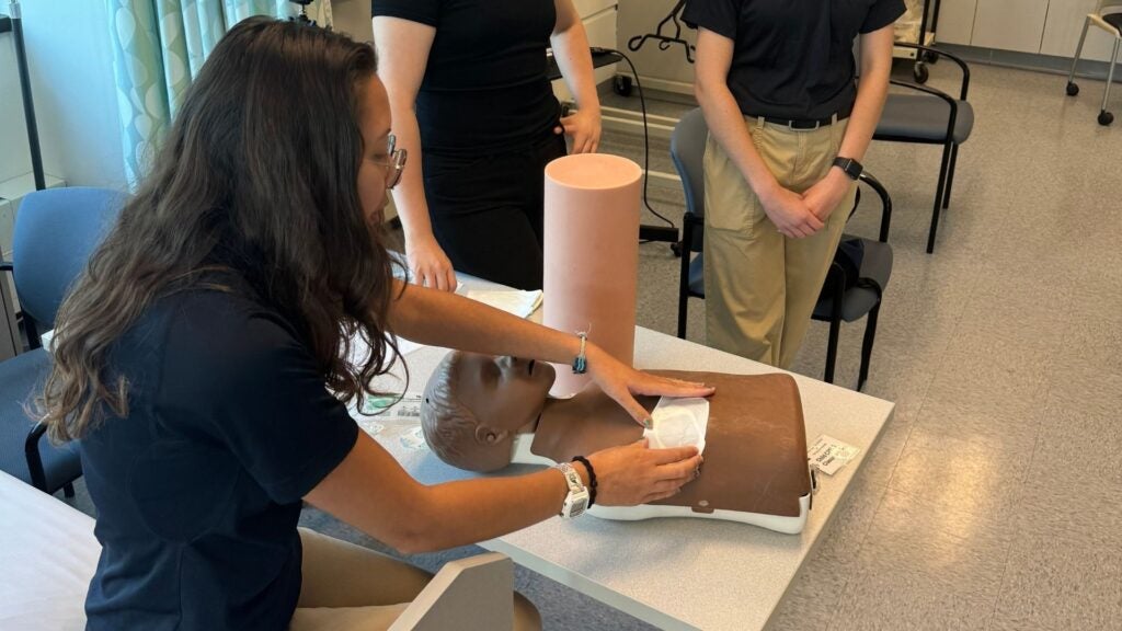 Student demonstrating First on the Scene procedures on a patient model during a training session.