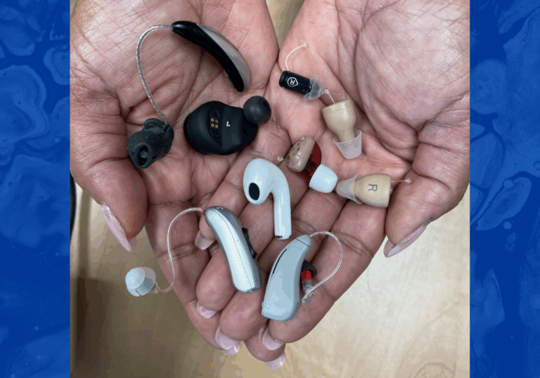 A pair of hands holds a variety of different hearing aids